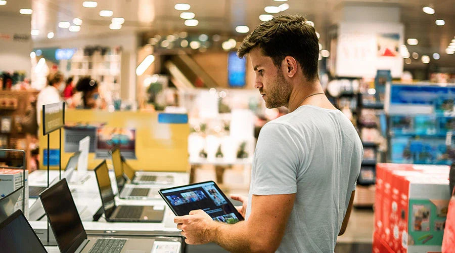 PayMore Abilene team member testing a laptop for resale value